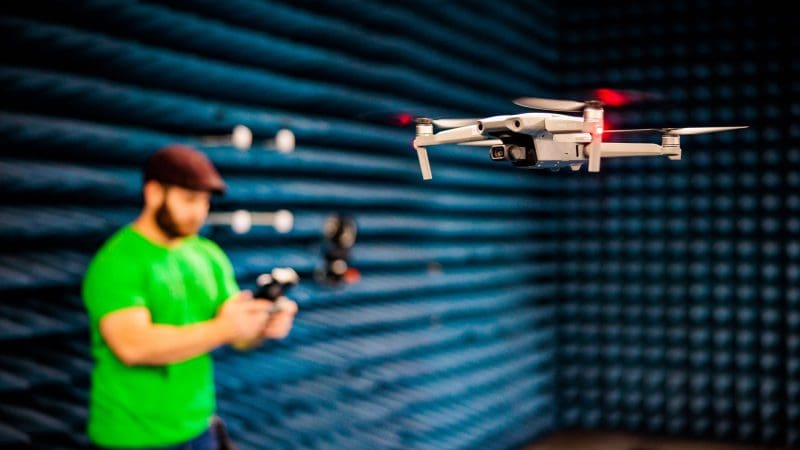 A man flying a drone in the indoor drone facility