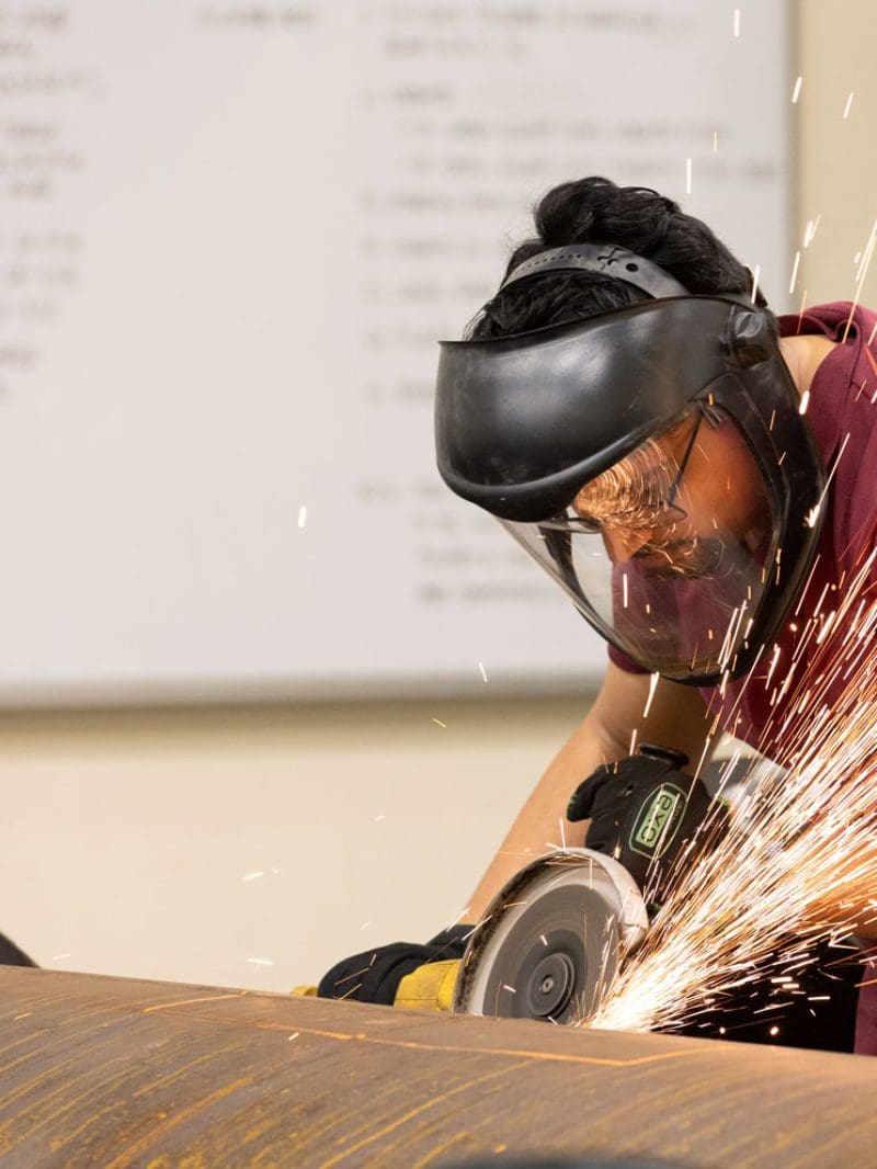 A man using a circular saw on metal creating sparks